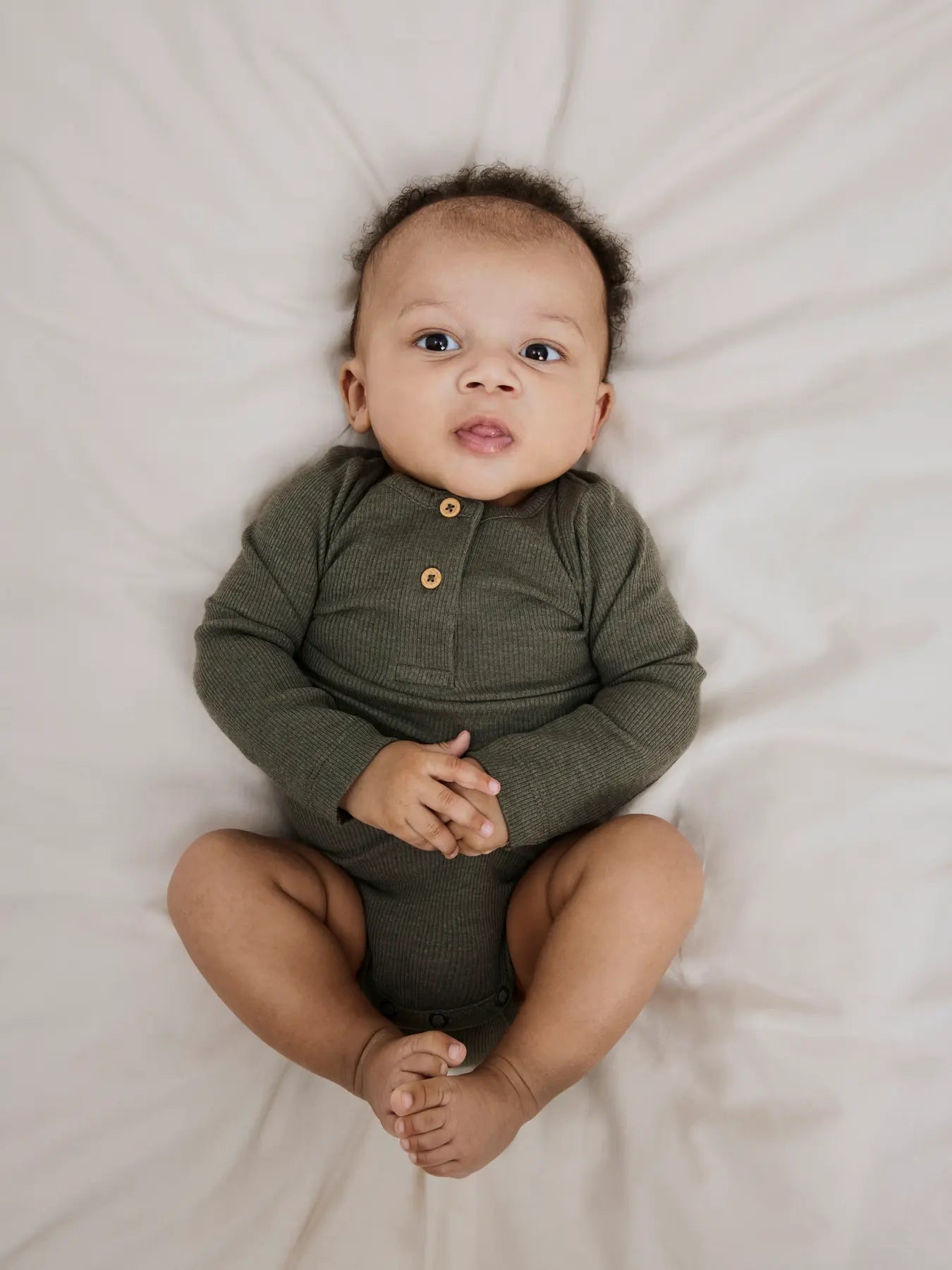 Baby trägt den Langarm Body in Dusty Olive von name it – gemütlich & alltagstauglich