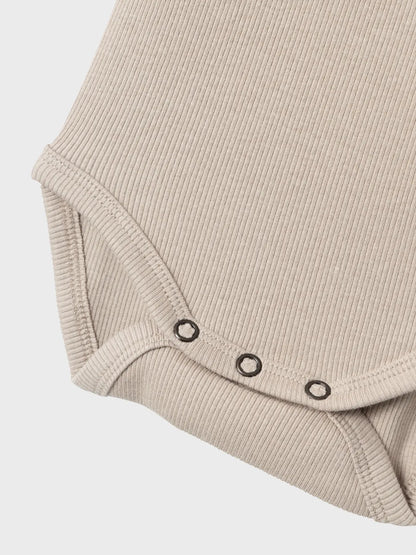 Detailaufnahme der praktischen Druckknöpfe am Body von name it – weich & funktional