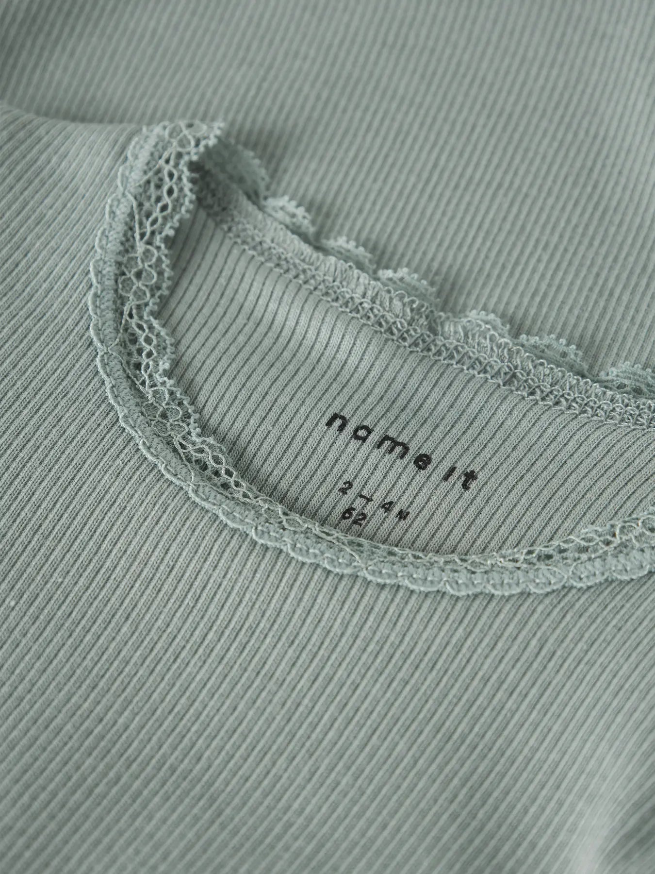 Detailaufnahme vom Rundhalsausschnitt mit Spitzenabschluss am Body von name it