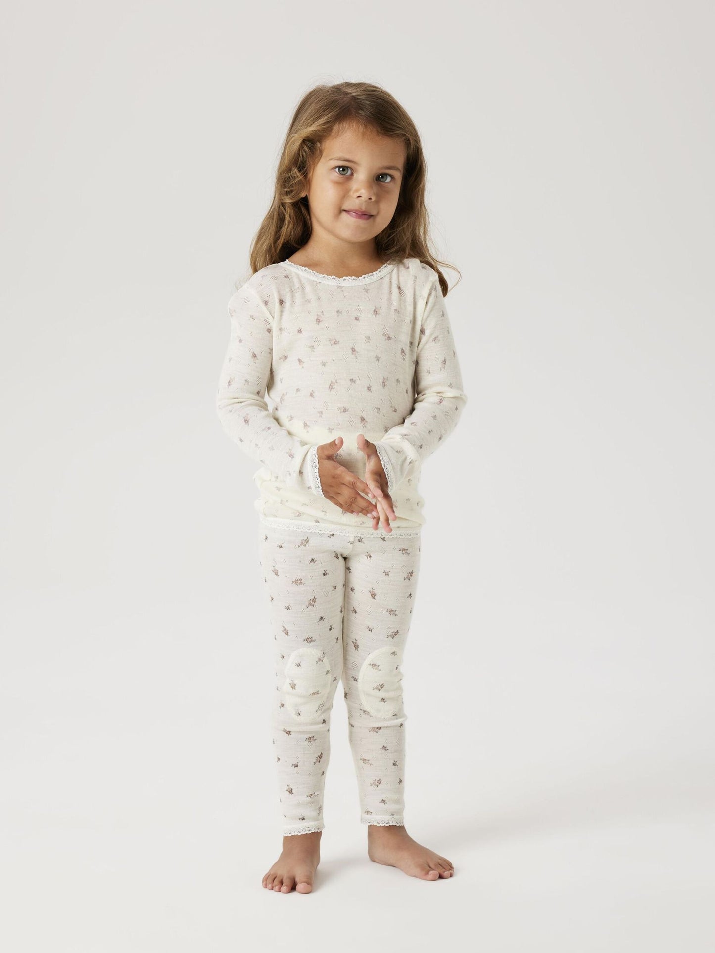 Kind trägt weisse Wollleggings mit feinem Blumenmuster von NAME IT