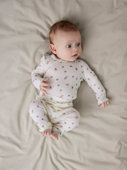 Ein Baby trägt Lil'Atelier Leggings mit zartem Blumenmuster und Spitzenabschluss in Winterthur.