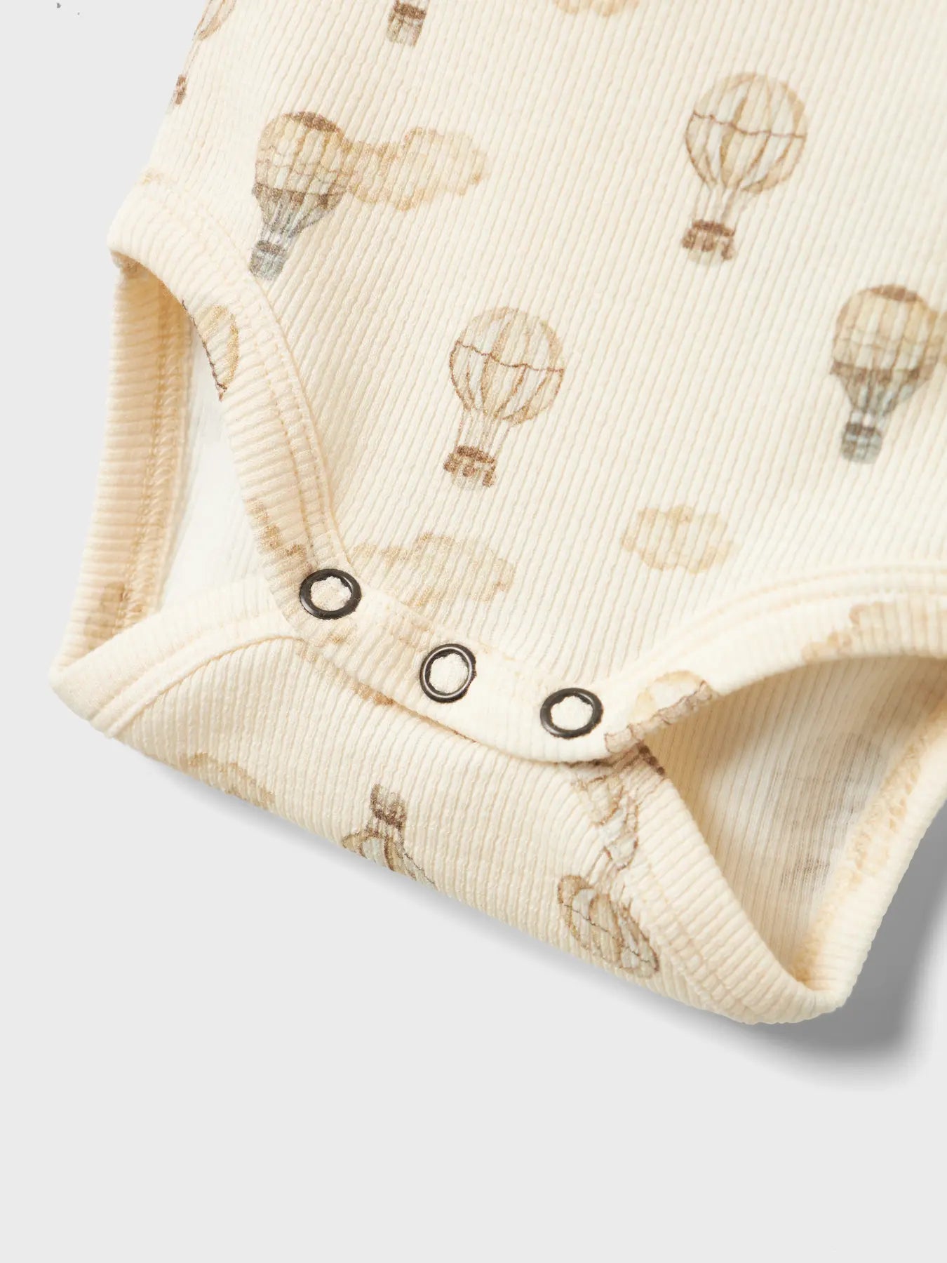 Detailansicht des Lil' Atelier Babybodys mit Heissluftballon-Print und praktischen Druckknöpfen – erhältlich bei Bärechind Winterthur.
