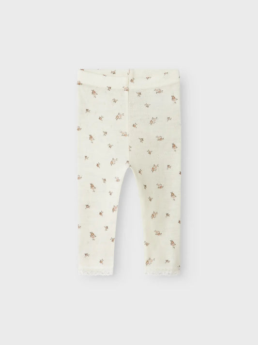 Baby-Leggings aus Wolle von Lil'Atelier mit floralem Muster auf hellem Stoff in Winterthur.
