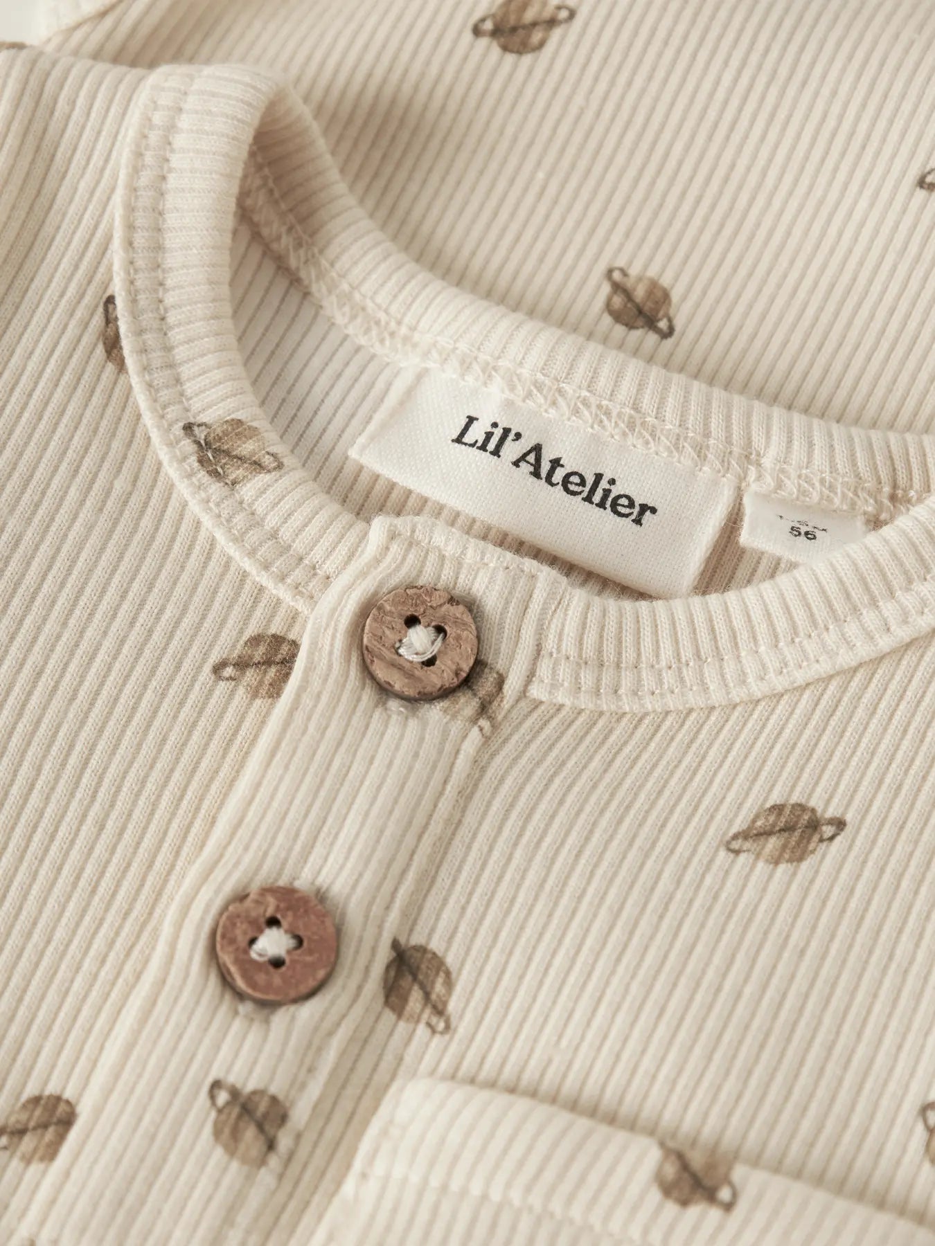 Detailaufnahme des LIL' ATELIER Ripp Bodys aus Baumwolle und TENCEL™ Lyocell mit Planetenprint, Knopfleiste und Brusttasche