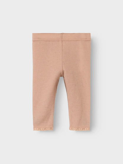 Detailaufnahme der Lil’Atelier Merino-Leggings mit Lochmuster und Spitzenabschluss in Winterthur.

