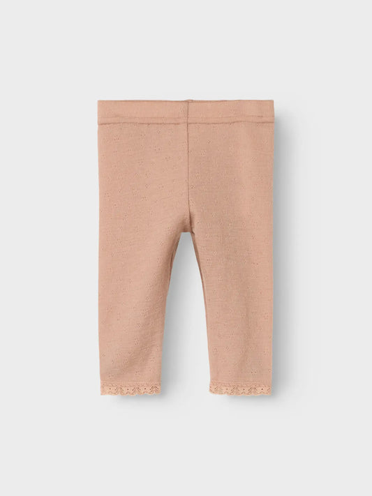 Detailaufnahme der Lil’Atelier Merino-Leggings mit Lochmuster und Spitzenabschluss in Winterthur.

