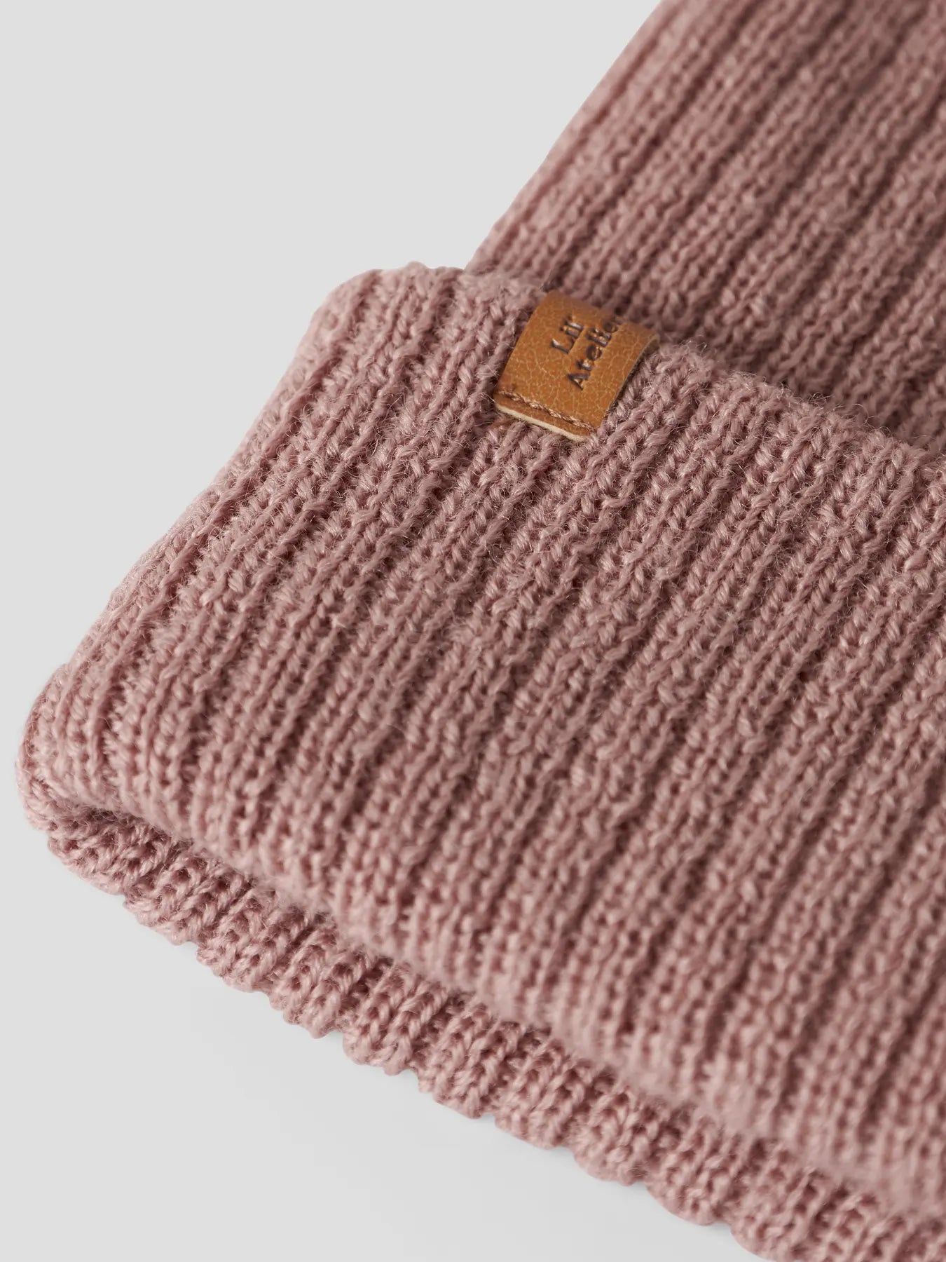 Nahaufnahme der rosa Lil'Atelier Kindermütze aus Wolle – erhältlich bei Bärechind Winterthur, Zürich Schweiz.