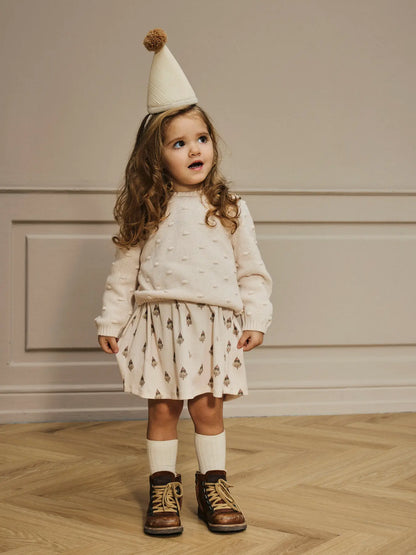 Kind trägt naturfarbenen LIL'ATELIER Pullover aus Bio-Baumwolle mit Struktur, erhältlich bei Bärechind in Winterthur, Zürich Schweiz.