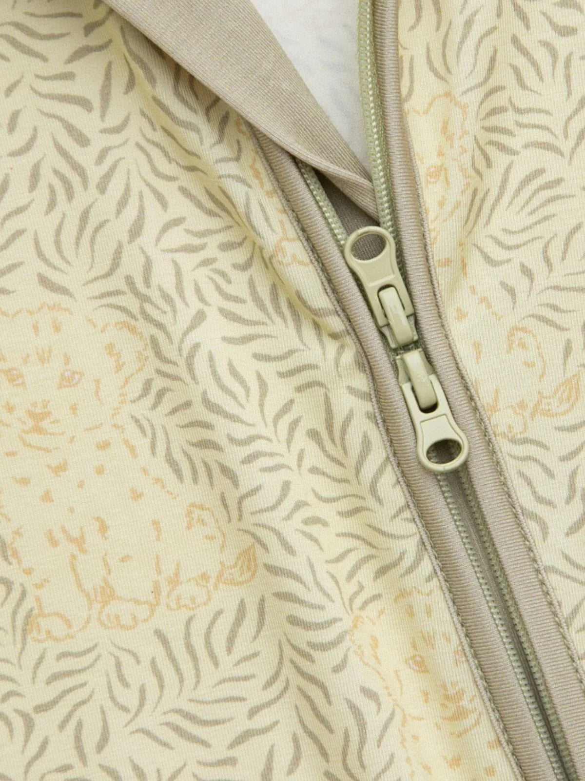 Detailaufnahme des LiluLila Zippy Stramplers mit praktischem Zwei-Wege-Reissverschluss und umklappbaren Füssen für eine längere Tragedauer.