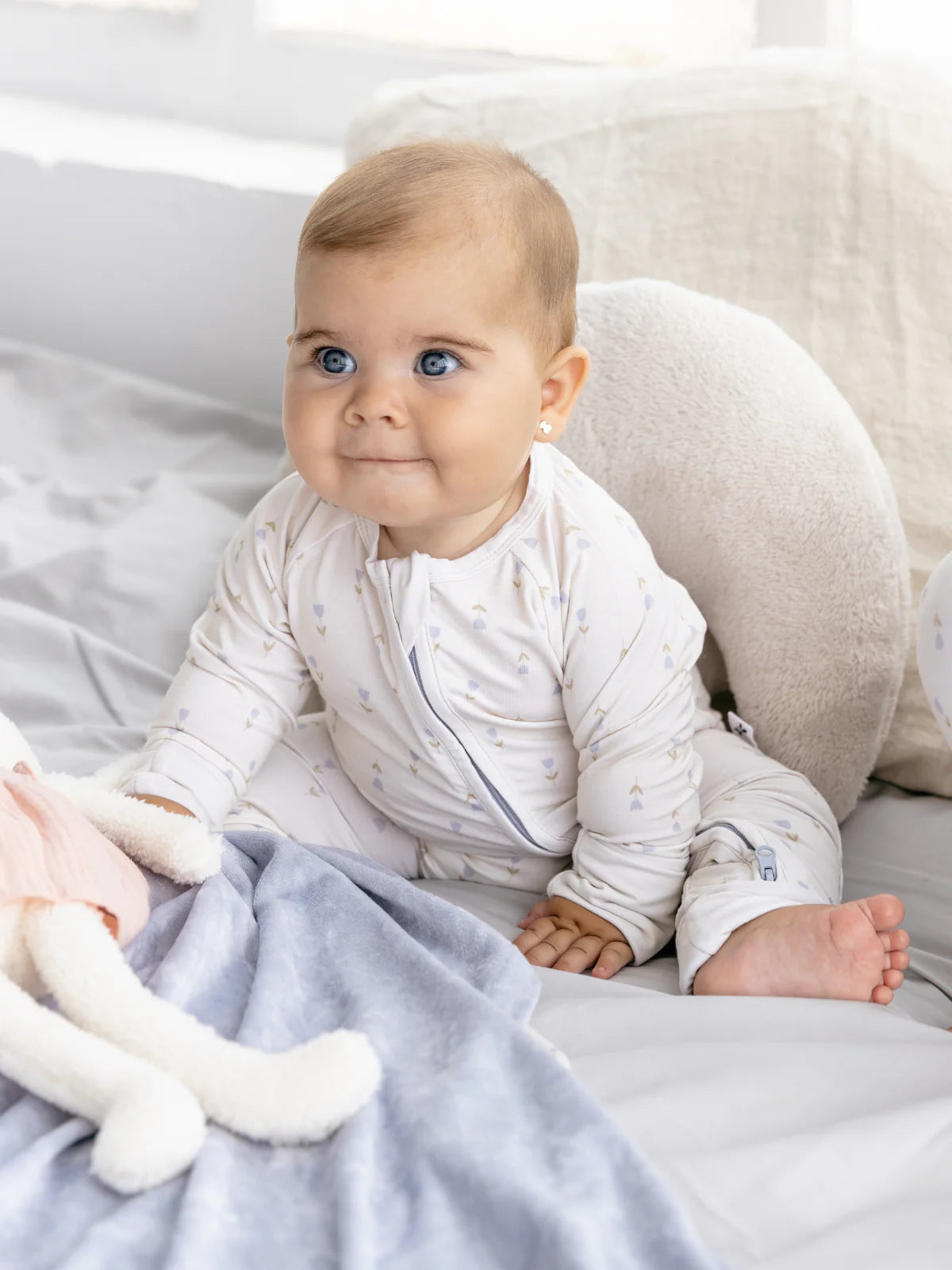 Baby trägt den LiluLila Tulpen Bambus Zippy Strampler. Nachhaltig, weich und atmungsaktiv – ideal für empfindliche Babyhaut in der Schweiz.