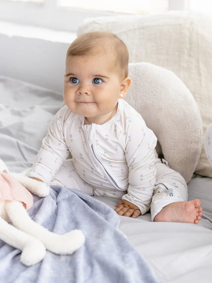 Baby trägt den LiluLila Tulpen Bambus Zippy Strampler. Nachhaltig, weich und atmungsaktiv – ideal für empfindliche Babyhaut in der Schweiz.