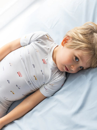 Kleinkind liegt entspannt im Bett mit dem kurzärmligen Bambus-Schlafanzug Little Ride – weich, atmungsaktiv & kindgerecht.