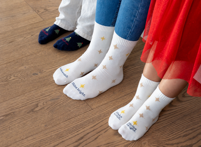 Kinderfüsse in Sternensocken und Tannenbaumsocken aus der Christmas Collection