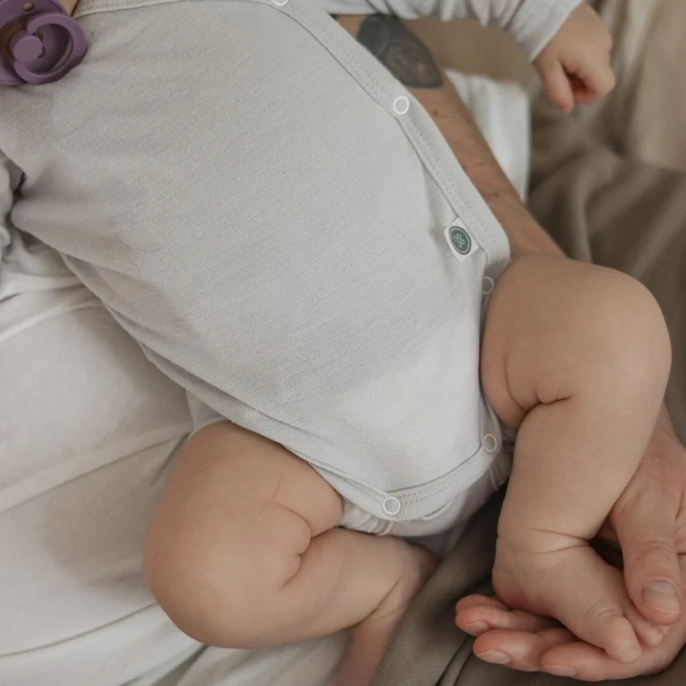 Detail der seitlichen Wickelöffnung am Emma & Noah Merino Wickelbody für Babys