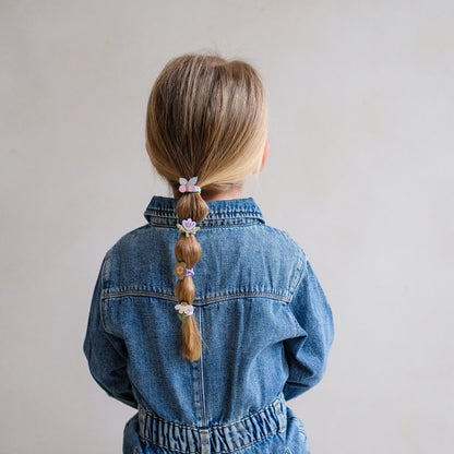 Kind trägt Mimi&Lula Haargummis mit Blume und Schmetterling im Zopf, erhältlich bei Bärechind in Winterthur, Zürich, Schweiz.