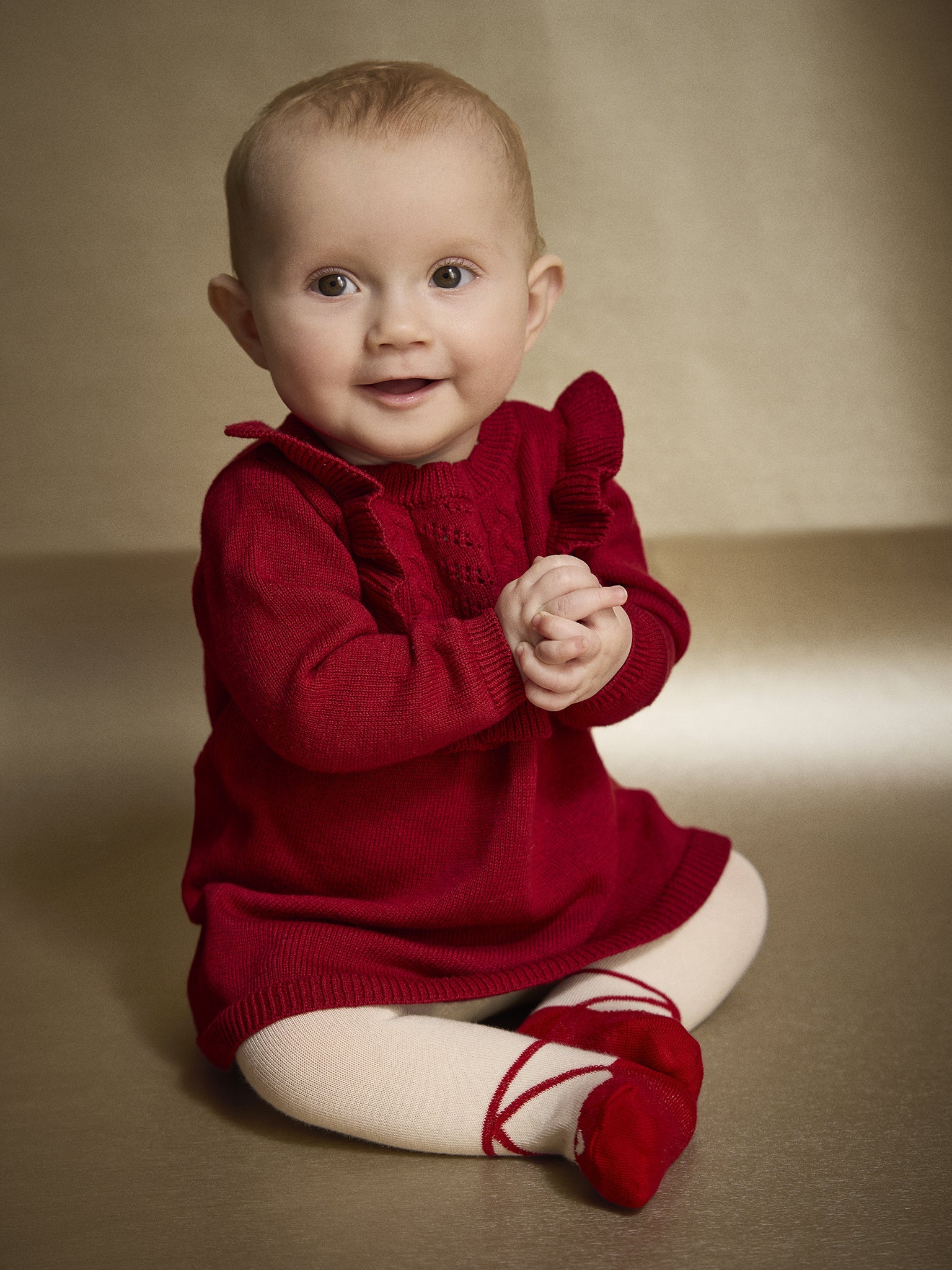 Baby trägt Minymo Strickkleid in Rio Red