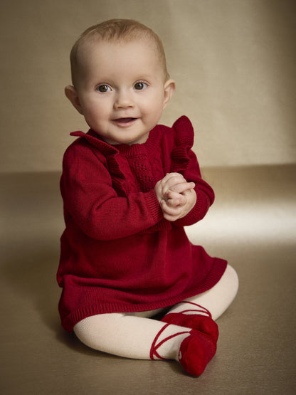 Baby trägt Minymo Strickkleid in Rio Red