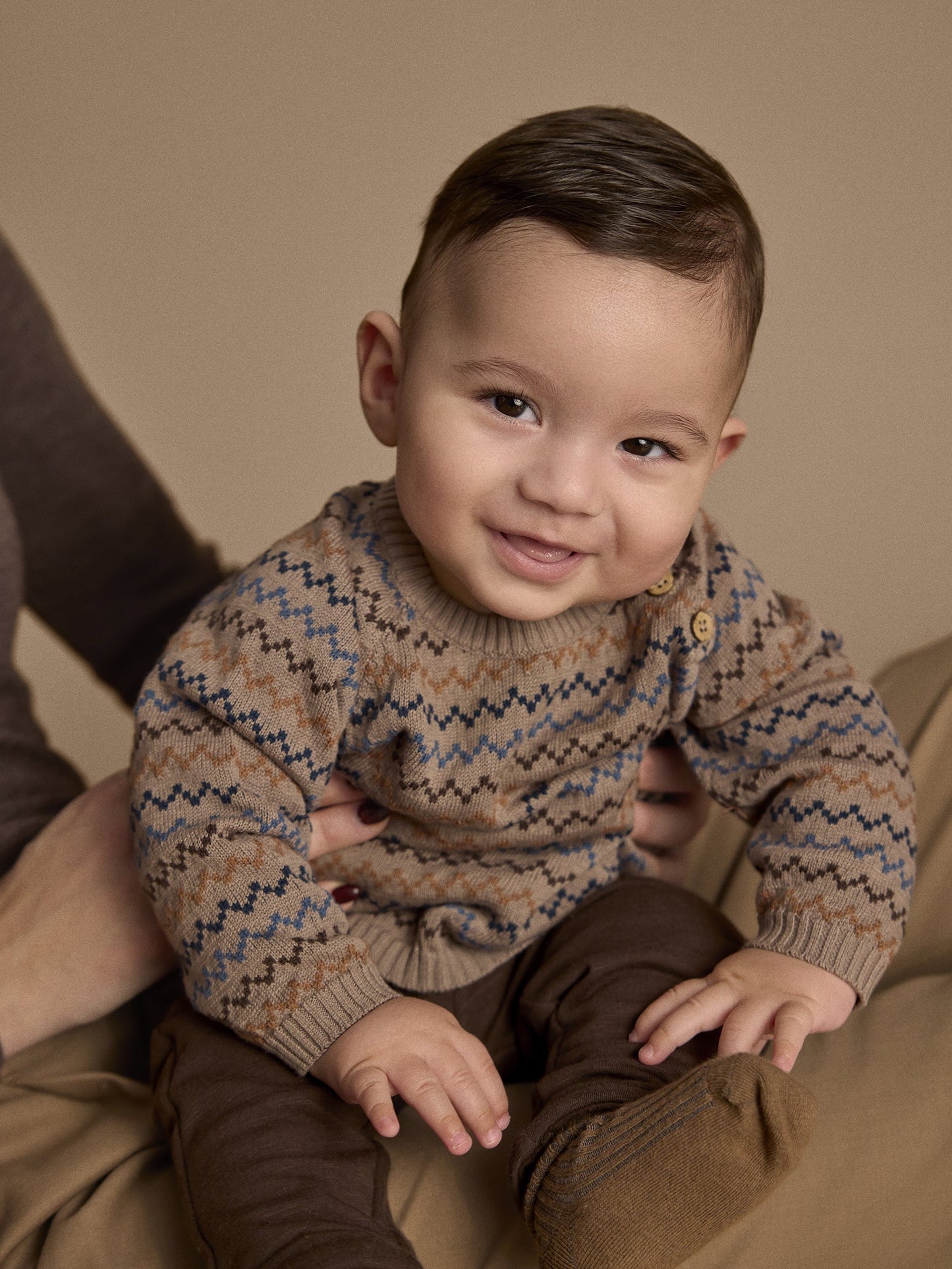 Baby trägt Minymo Strickpullover in Fungi