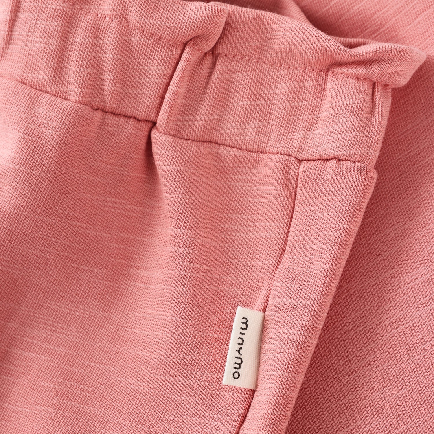 Detailaufnahme Bund und Label der Minymo Sweat Hose aus Bio-Baumwolle in Rose im Bärechind Winterthur, Zürich, Schweiz