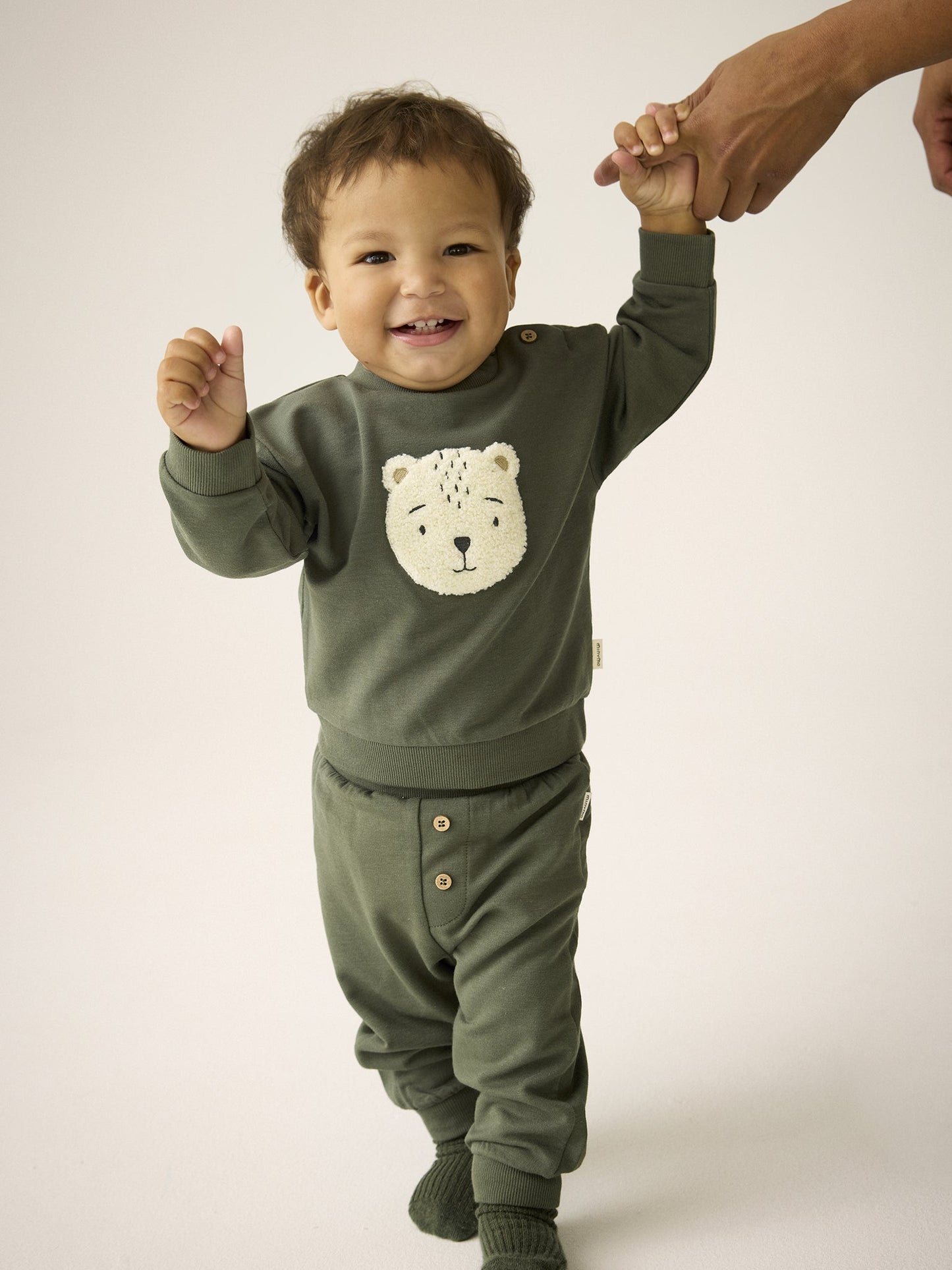 Baby trägt Minymo Sweatshirt in Beetle