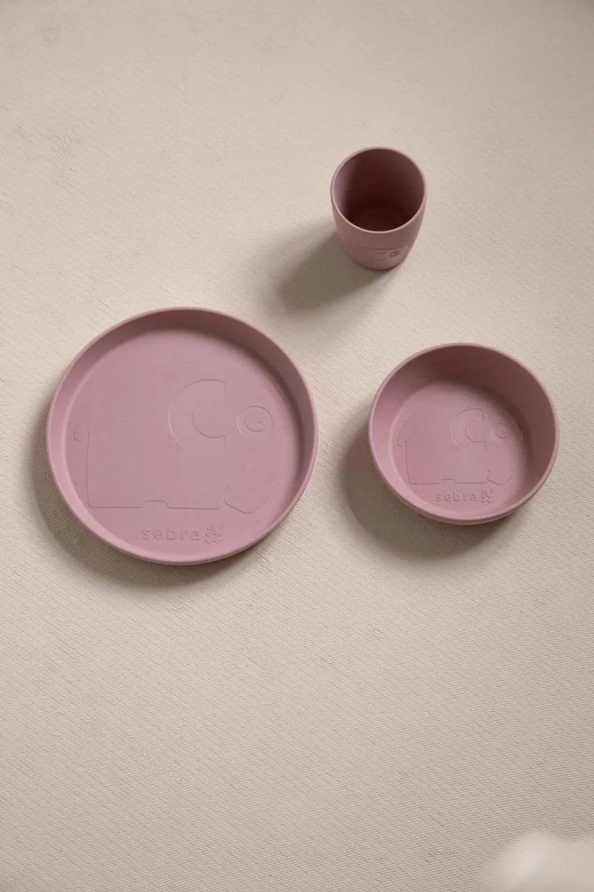 Rosa Teller, Schale und Becher des MUMS-Sets als Flatlay auf einem hellen Untergrund arrangiert.