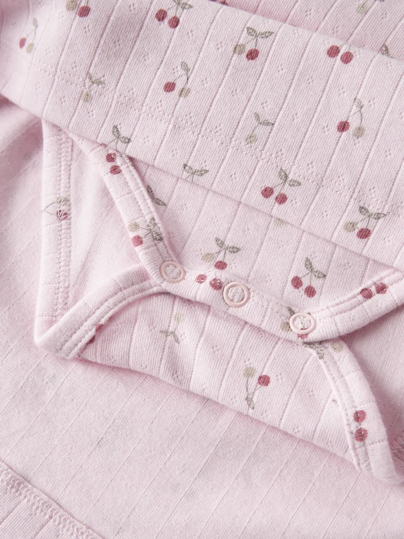 Detail Kirsch Print und Druckknöpfe am NAME IT Kleid Body aus Baumwolle zu kaufen im Bärechind Winterthur Zürich Schweiz.