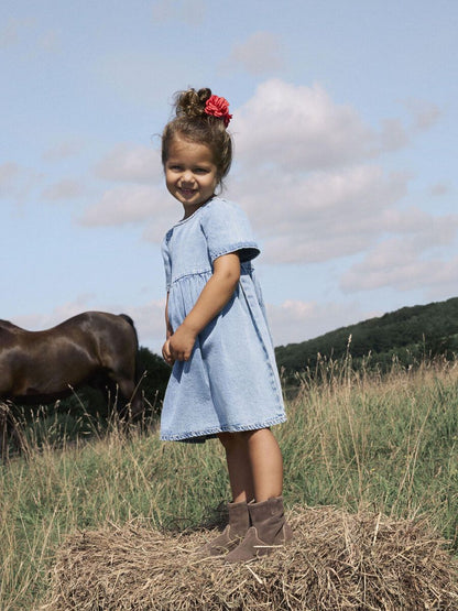 Kind trägt name it Denim Kleid – luftiges Jeanskleid mit kurzen Ärmeln, erhältlich bei Bärechind in Winterthur