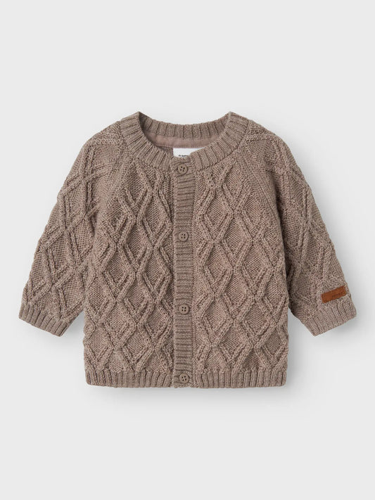 Eine braune Merino Strickjacke von Name It mit Rautenmuster und Knöpfen, fotografiert in Winterthur.