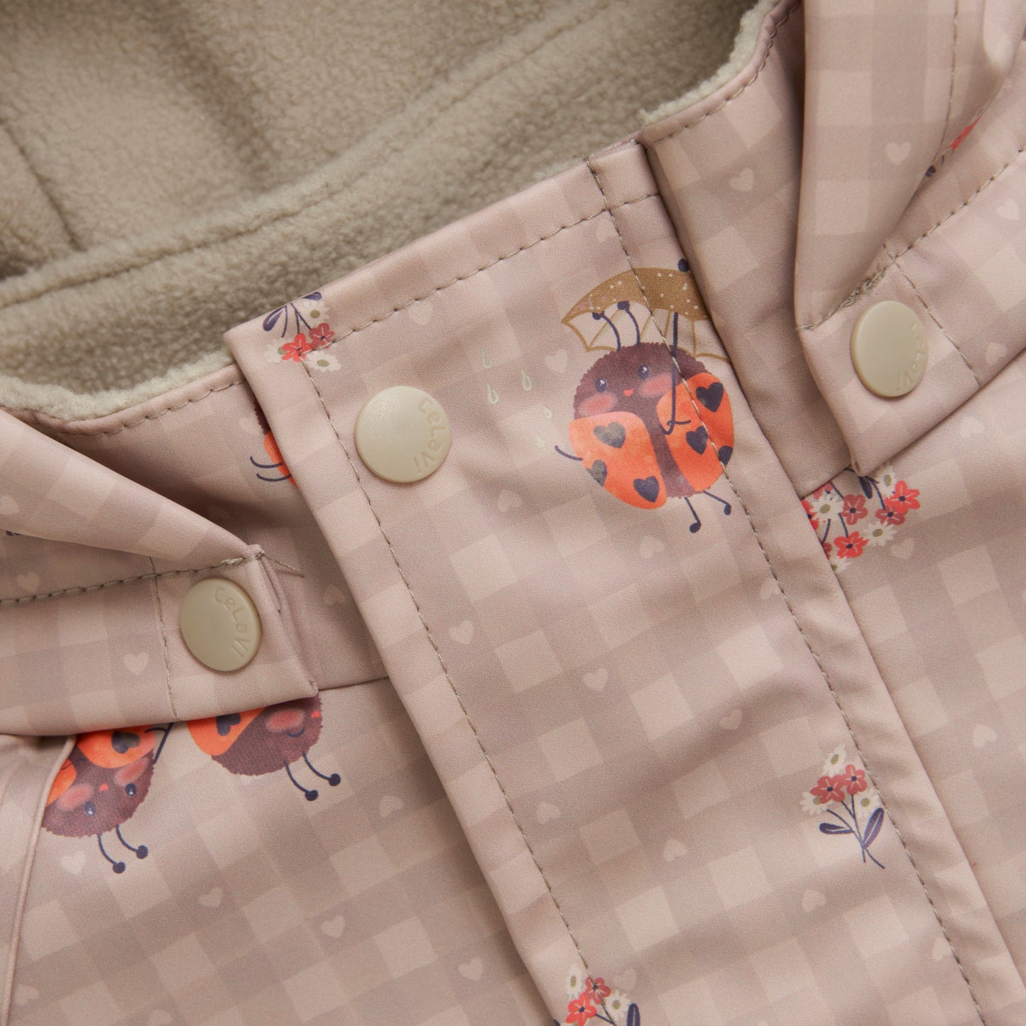 Detailaufnahme CeLaVi Regenoverall beige mit Marienkäfer-Muster, erhältlich im Bärechind Winterthur Zürich Schweiz.