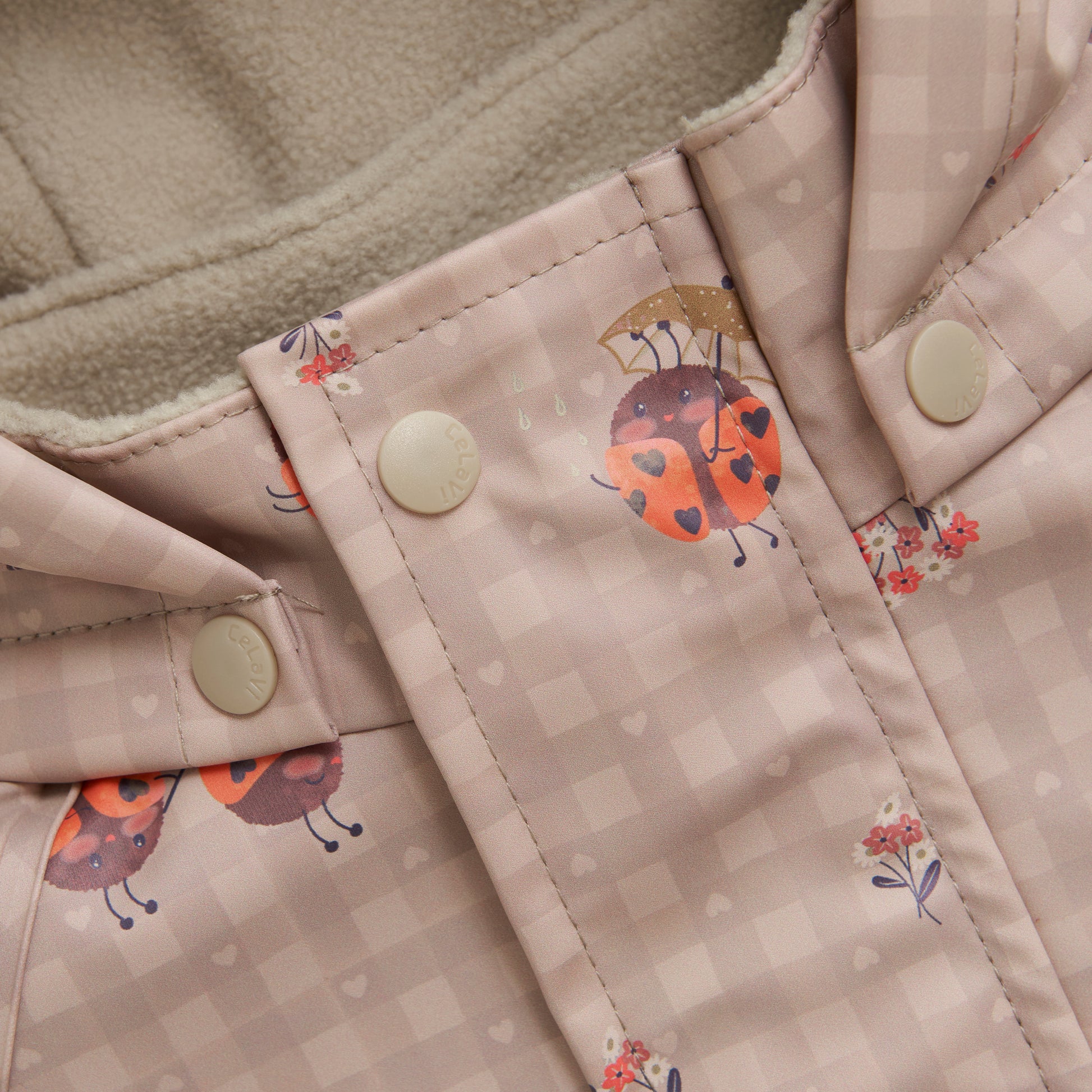 Detailaufnahme CeLaVi Regenoverall beige mit Marienkäfer-Muster, erhältlich im Bärechind Winterthur Zürich Schweiz.