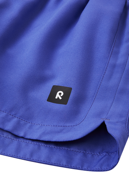Detailaufnahme Logo & Saum der Reima Nauru Badeshorts – in Lila mit UV-Schutz
