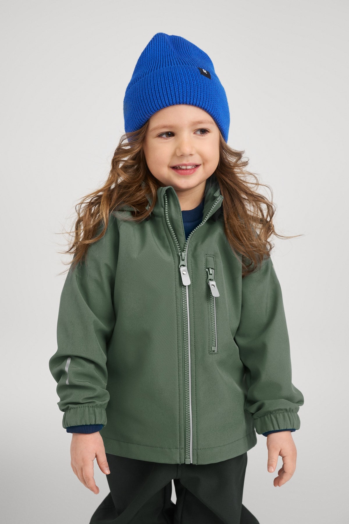 Kind trägt die Reima Softshelljacke Vantti Thyme Green erhältlich im Bärechind Schweiz