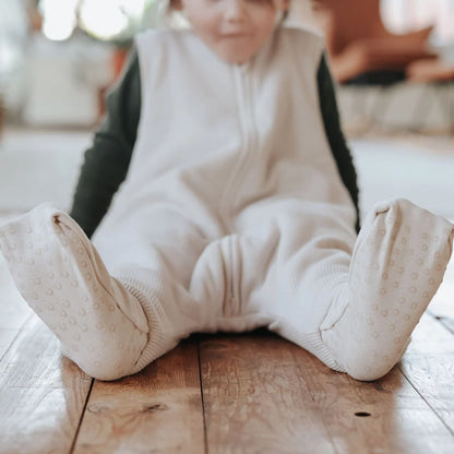 Emma & Noah Schlafsack in Beige mit umgeklappten Fussbündchen an einem Kind, erhältlich im Bärechind in Winterthur und online in der Schweiz.