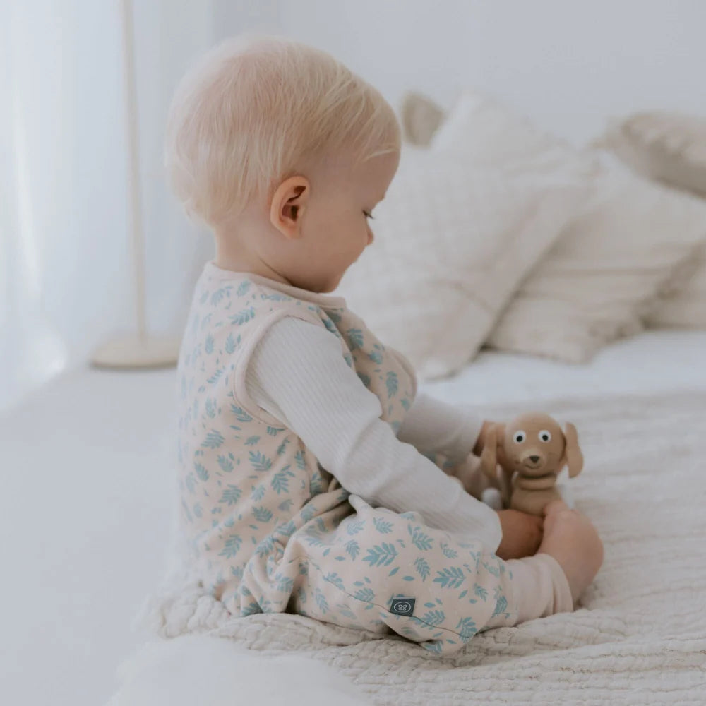 Baby im Emma & Noah Schlafsack mit Füssen und Vogelprint beim Sitzen, erhältlich im Bärechind in Winterthur bei Zürich und online in der Schweiz.