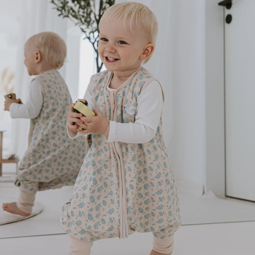 Kleinkind im Emma & Noah Schlafsack mit Füssen und dezentem Vogelprint, erhältlich im Bärechind in Winterthur, Zürich, Schweiz.