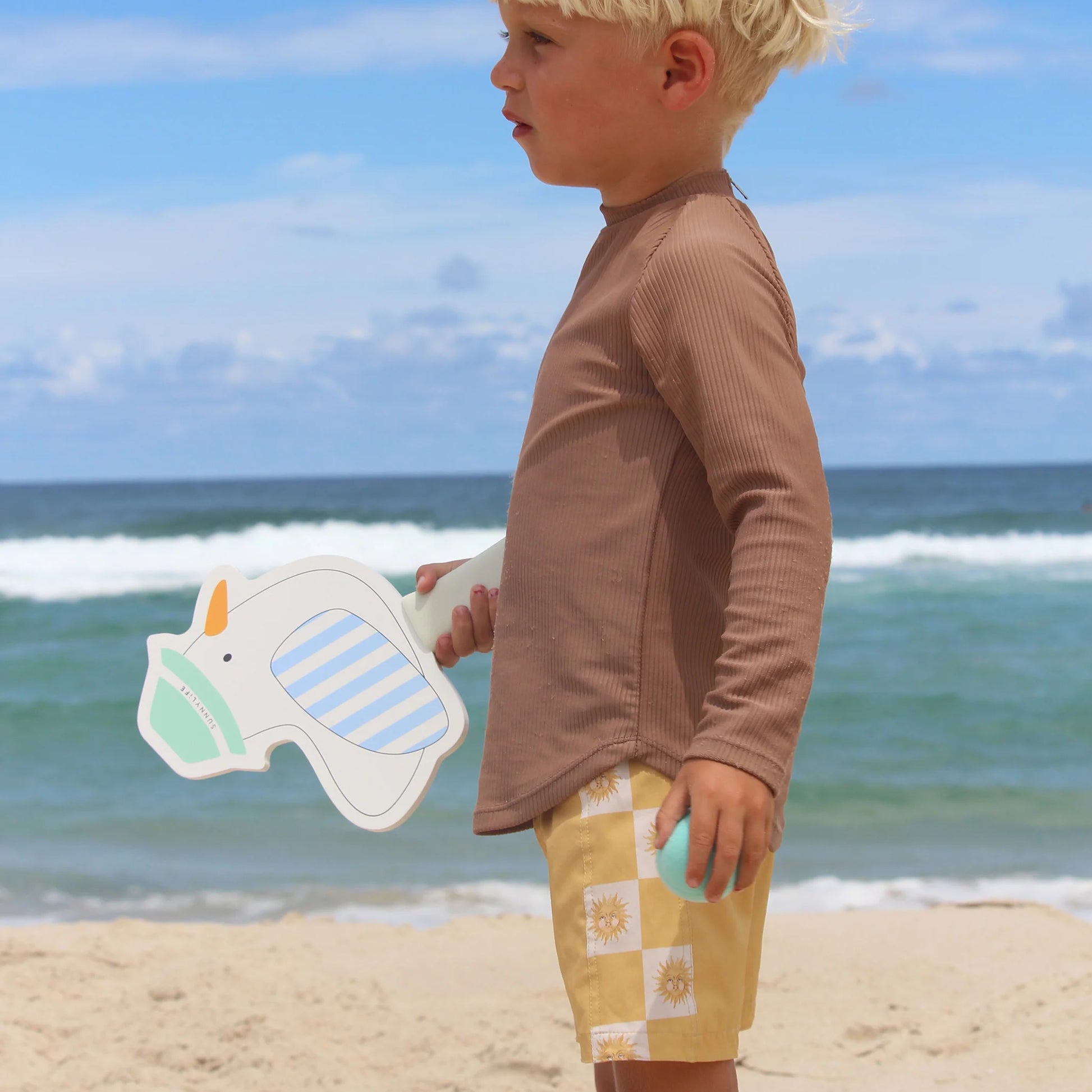 Kind spielt mit SunnyLife Strandschläger Set am Strand – Möwen-Design in Blau