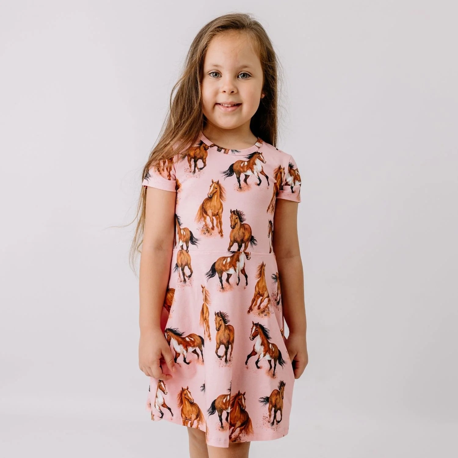 Kind trägt Walkiddy Kinderkleid mit Pferde Print aus Bio Baumwolle – Bärechind Kinderladen Winterthur Zürich Schweiz.