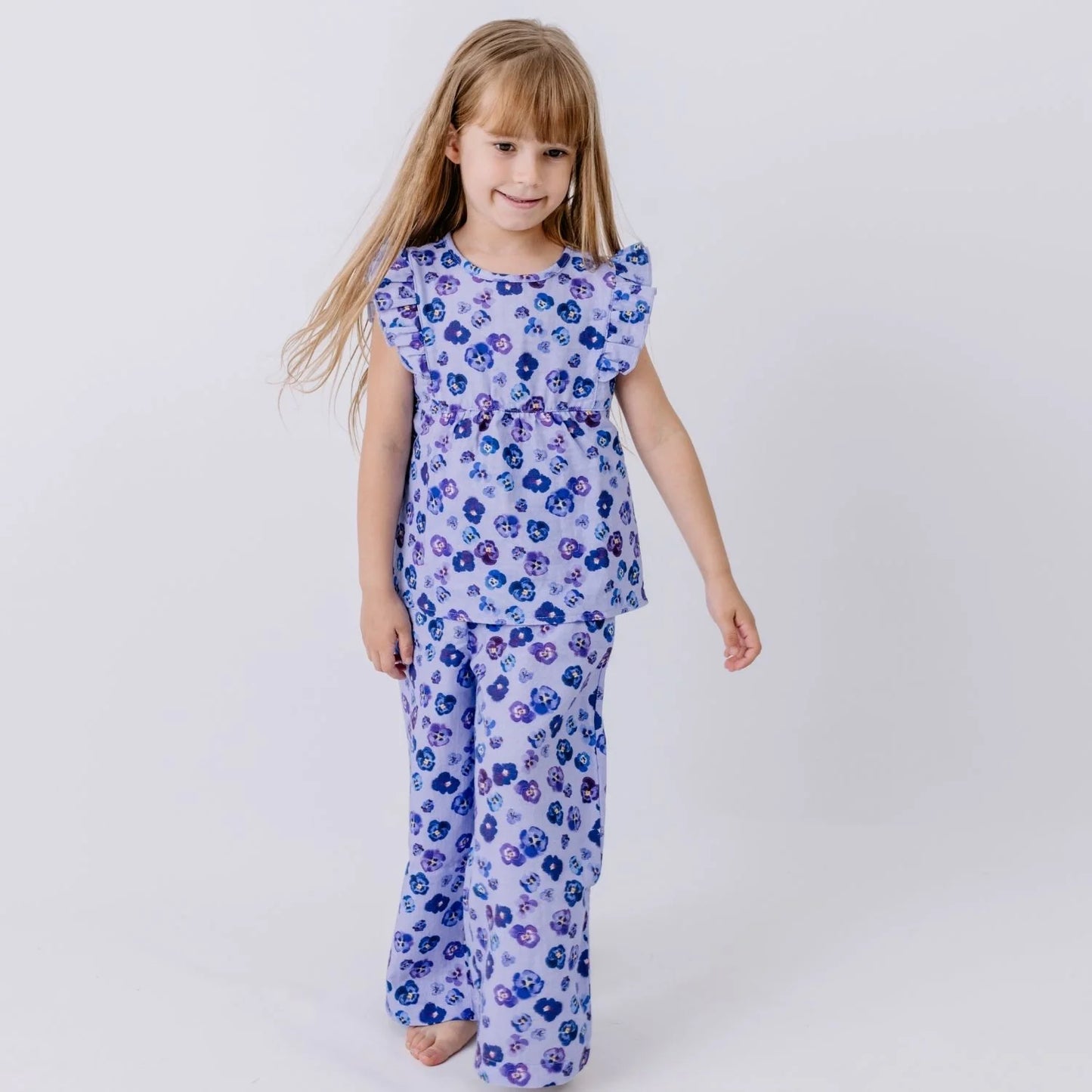 Kind trägt Walkiddy Musselin Kinderhose mit Veilchen Print – nachhaltige Kindermode bei Bärechind Winterthur Zürich Schweiz