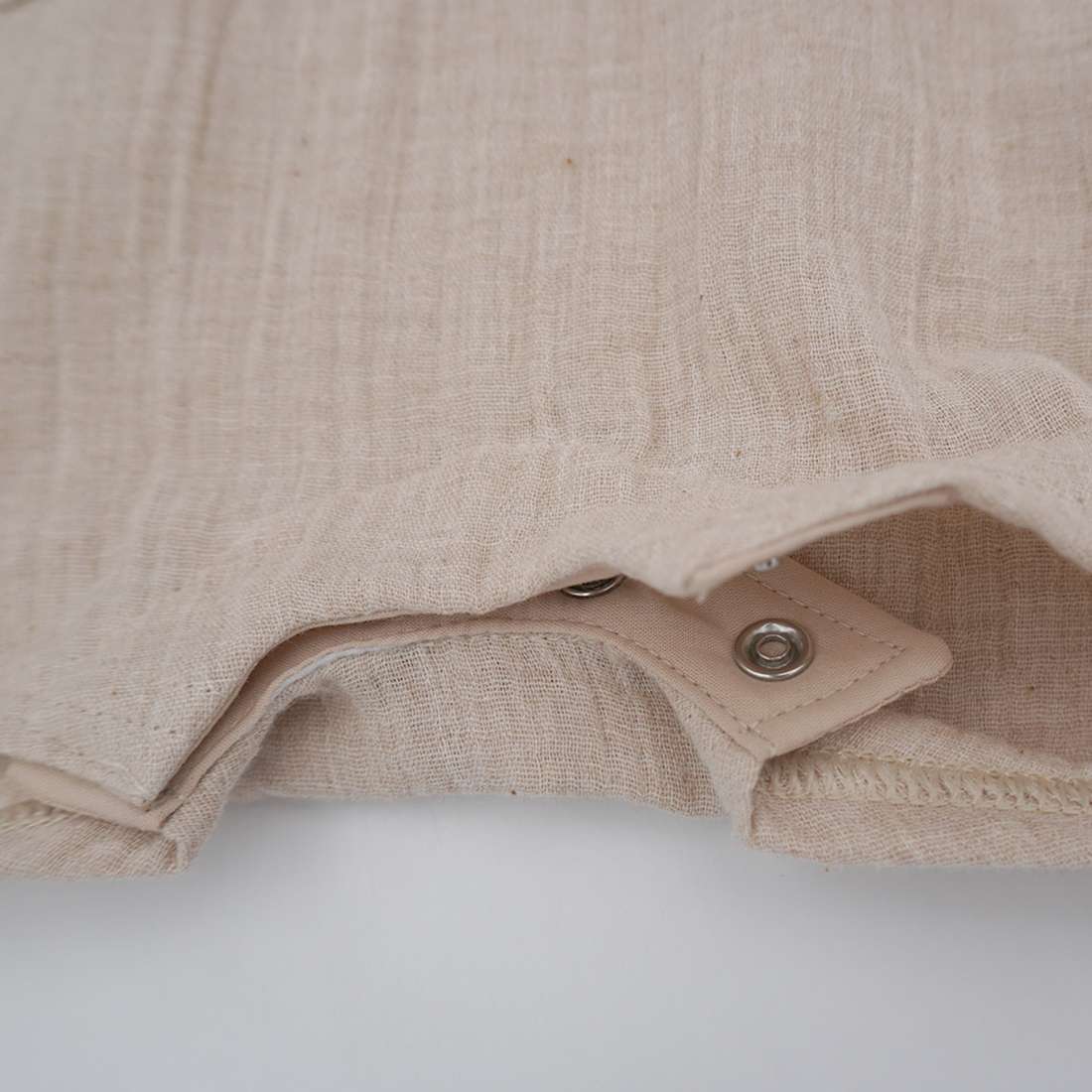 Detailaufnahme der Windelöffnung mit Druckknöpfen und Innenfutter der GOTS Baby-Latzshorts