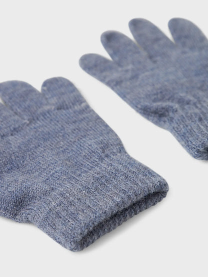 Detailansicht eines blauen Strickhandschuhs aus Wolle mit Bündchen.