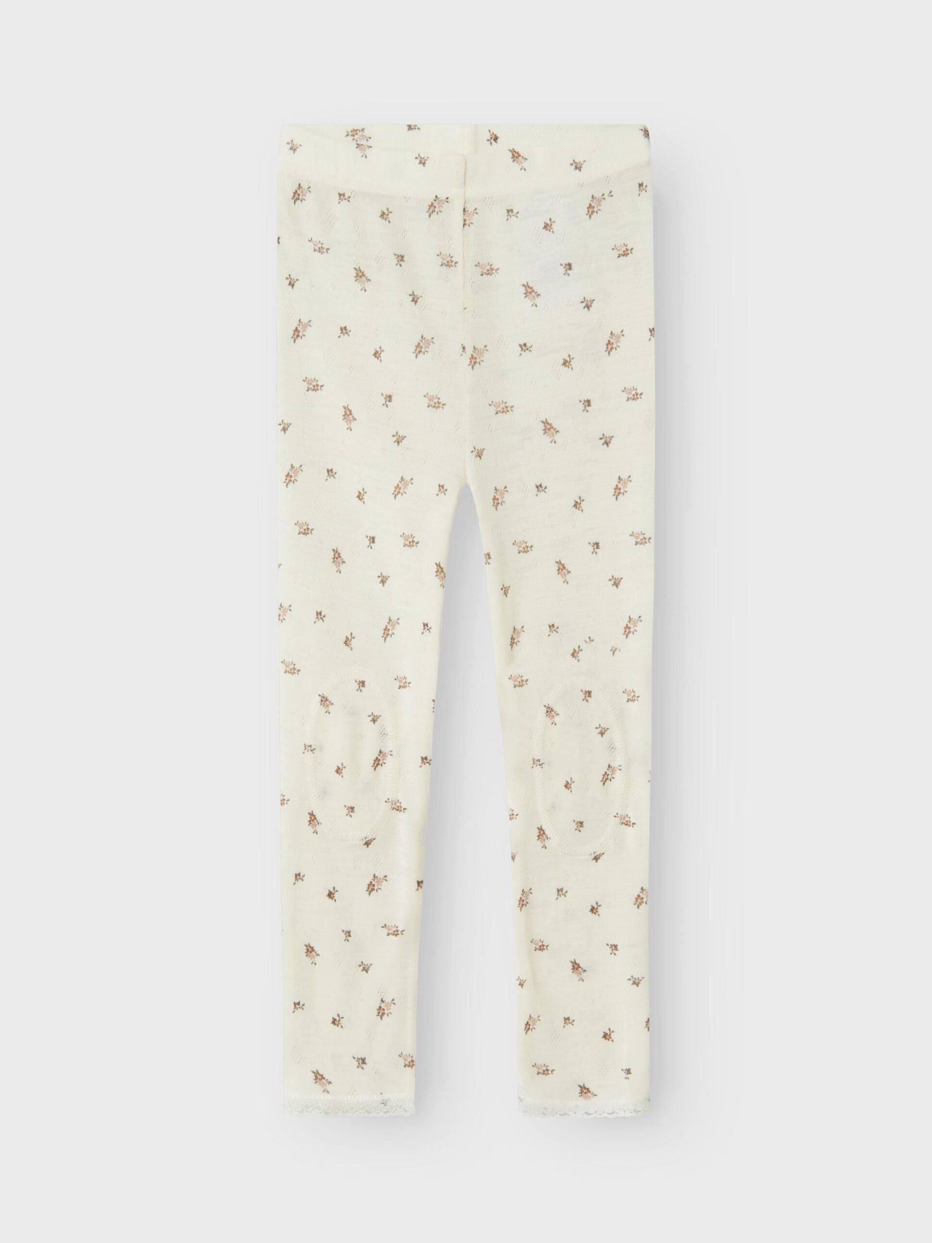 Weisse Wollleggings mit kleinem Blumenmuster aus Merinowolle, flachliegend
